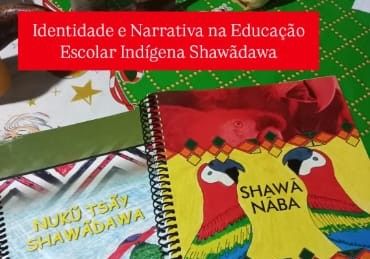 Dois livros didáticos Shawãdawa sobre uma mesa: Nukũ Tsãy Shawãdawa e Shawã Nãba, este com duas araras desenhadas na capa.